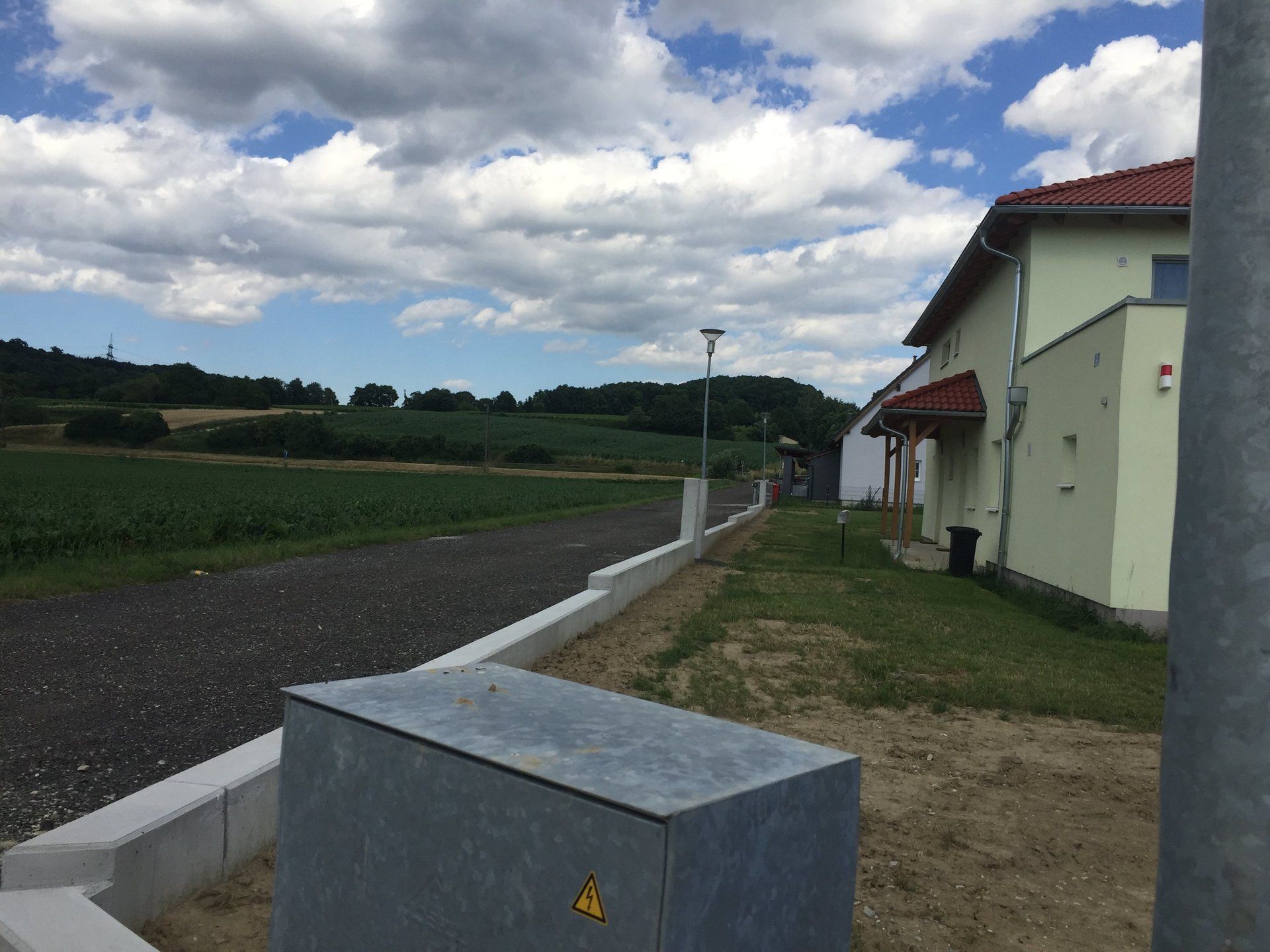 Eine Kiste mit einem gelben Warnschild steht vor einem Haus