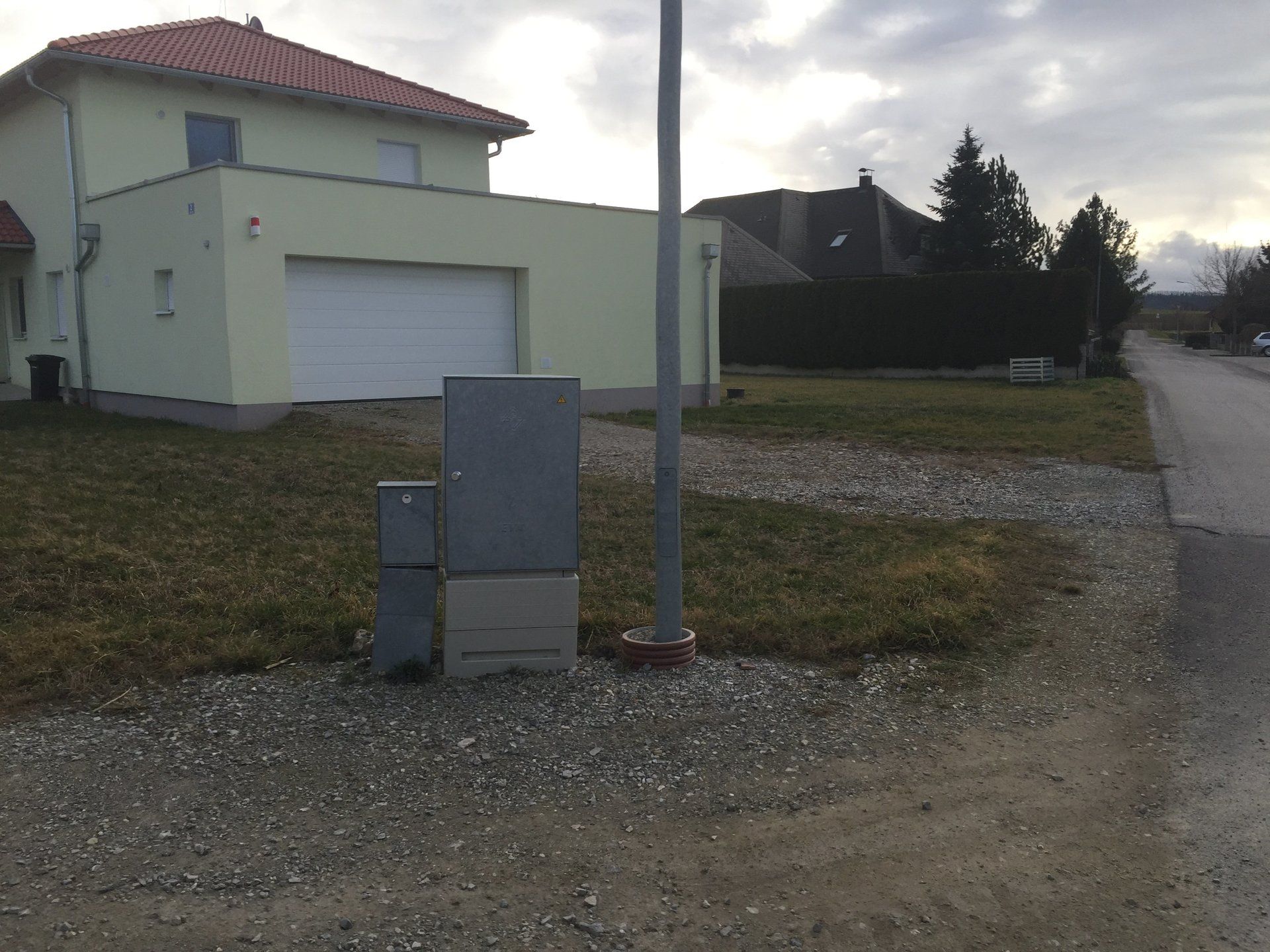 Ein Haus mit einem weißen Garagentor und einem roten Ziegeldach