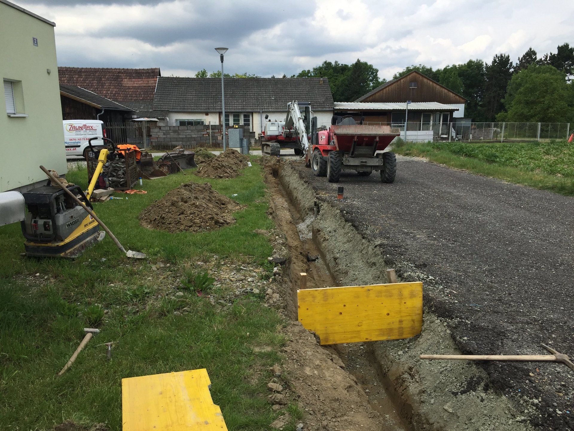 Ein LKW fährt auf einer unbefestigten Straße neben einem Gebäude