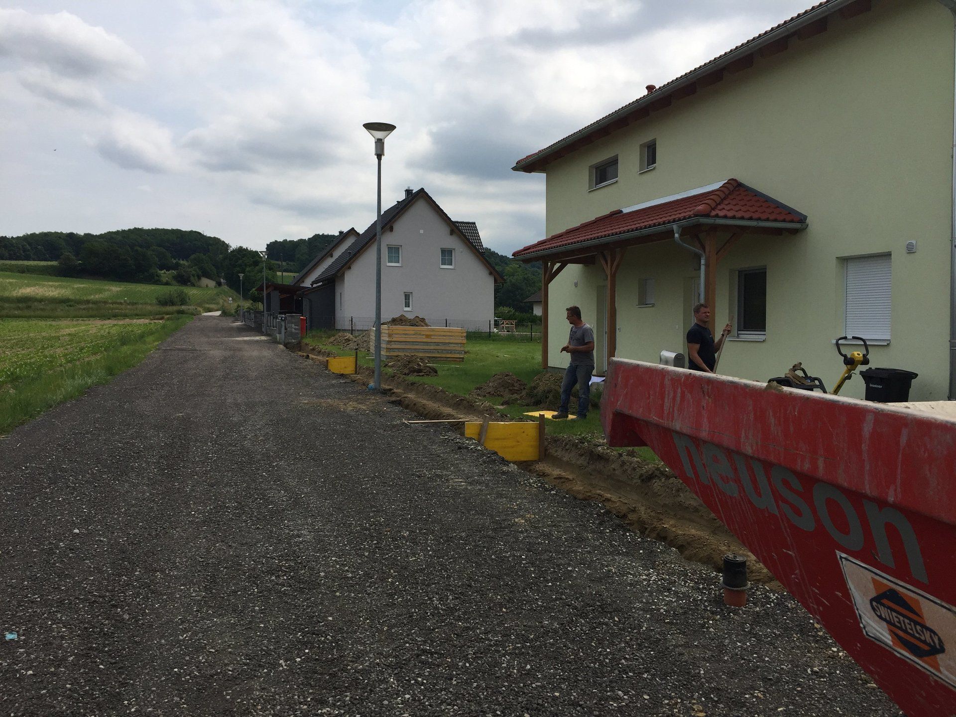 Ein roter Müllcontainer steht vor einem Haus