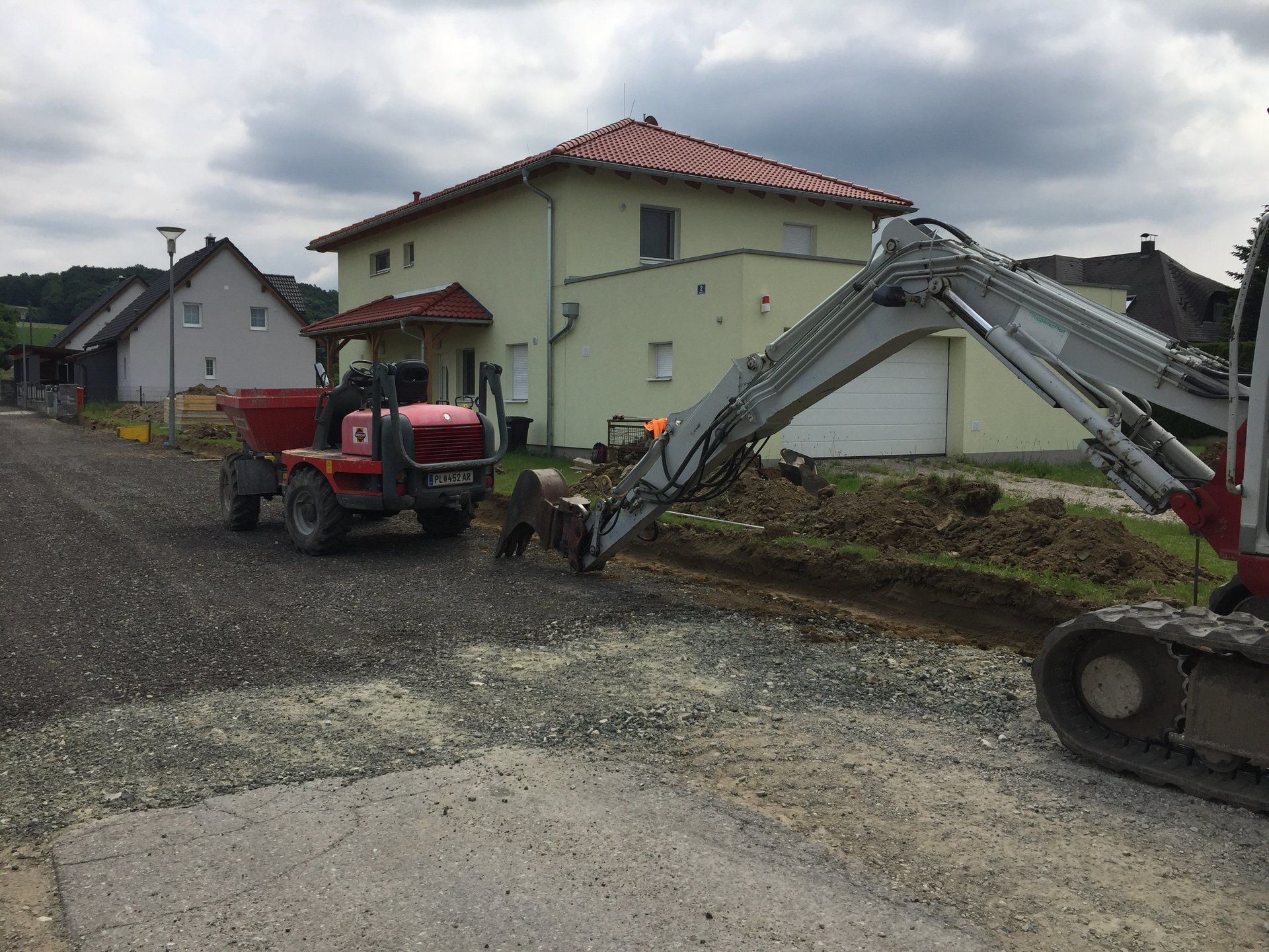 Ein roter Traktor steht vor einem Haus