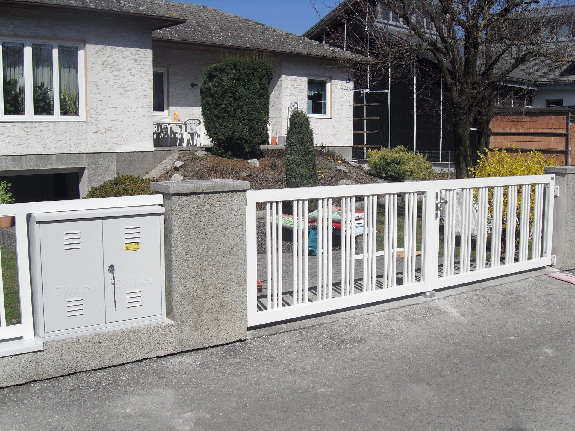 Ein Haus mit einem weißen Zaun davor