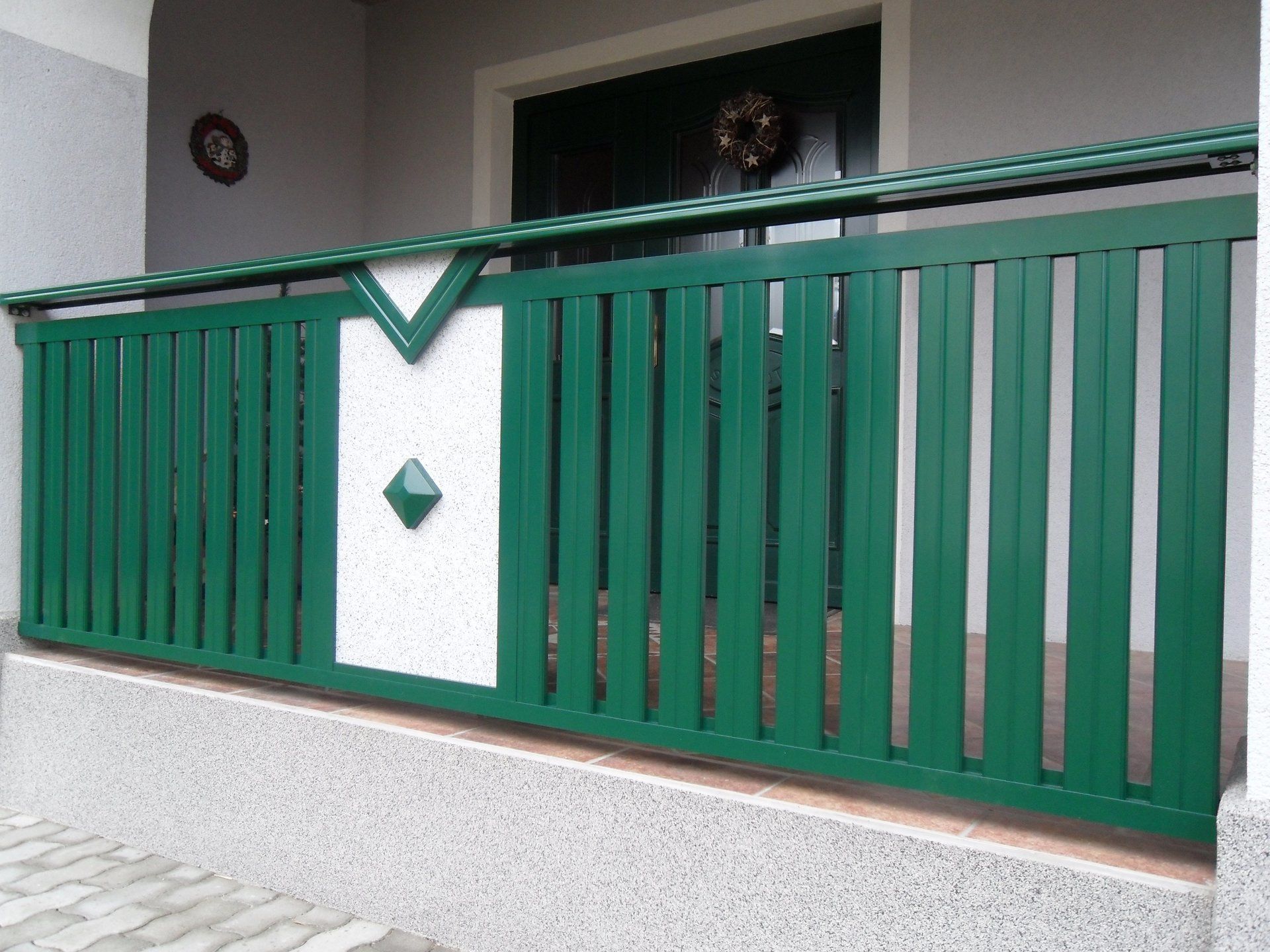 Ein grün-weißer Zaun mit einer Raute in der Mitte