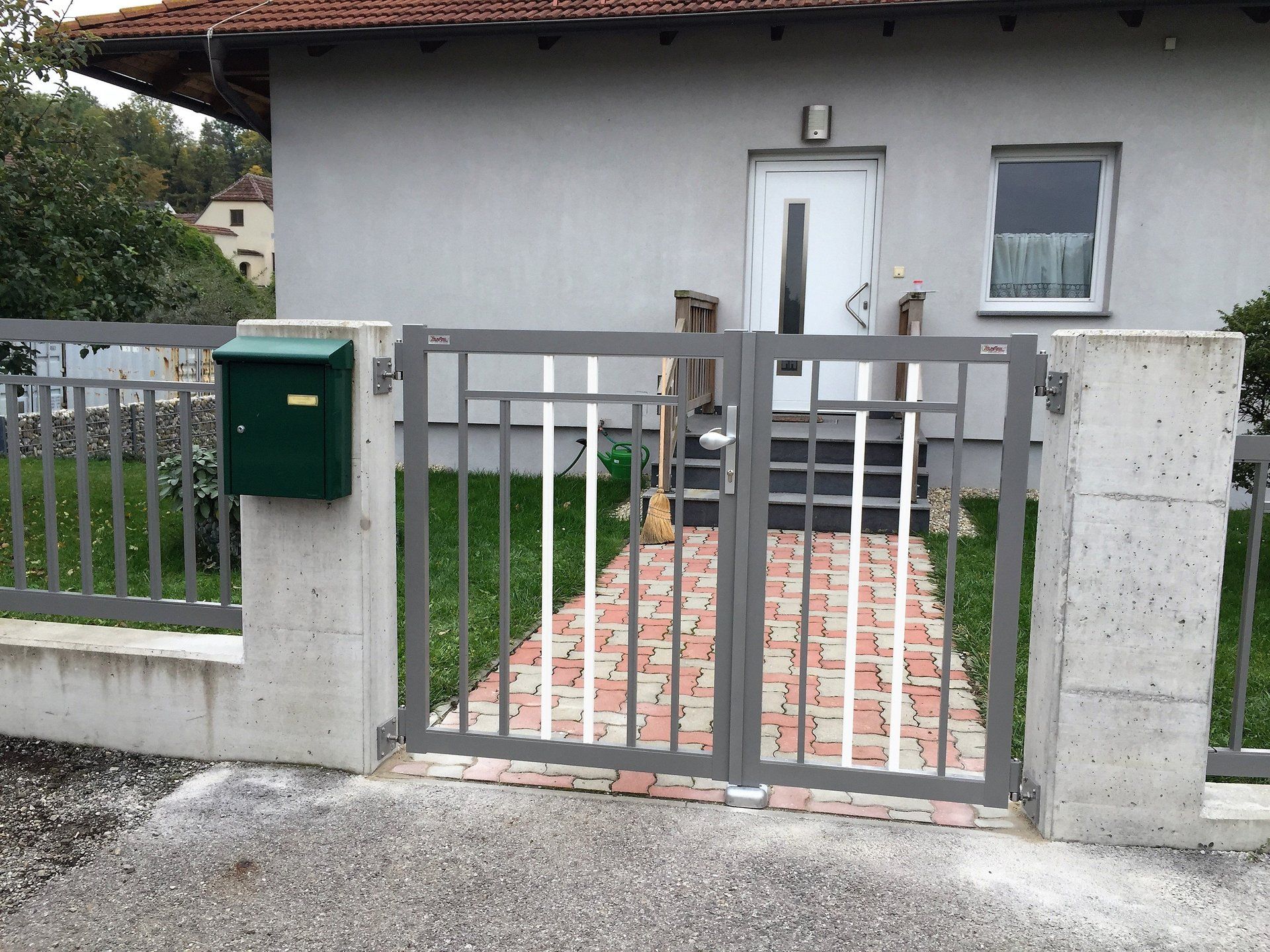 Ein Haus mit einem Tor und einem Briefkasten davor