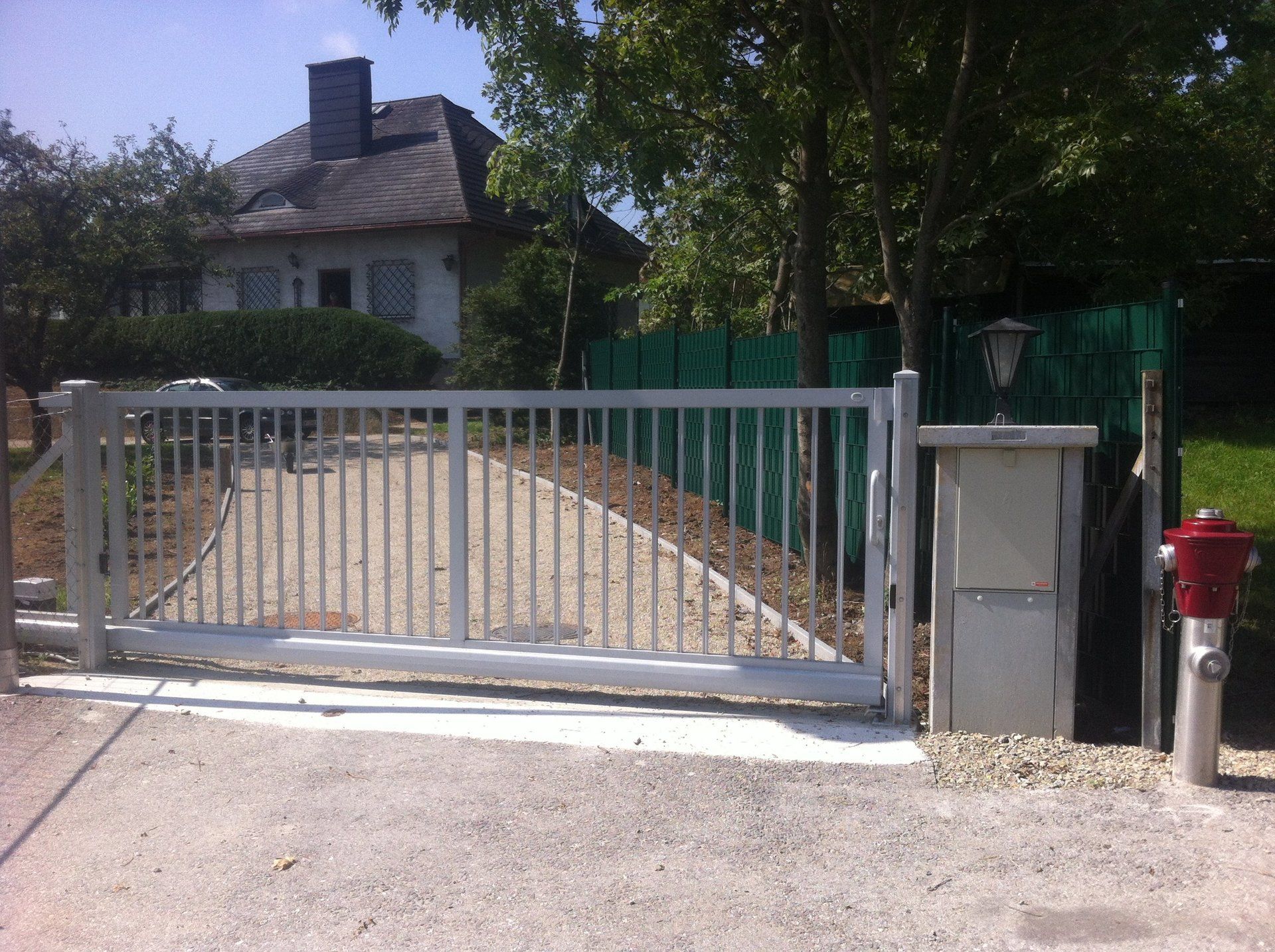 Ein Schiebetor mit einem Hydranten davor