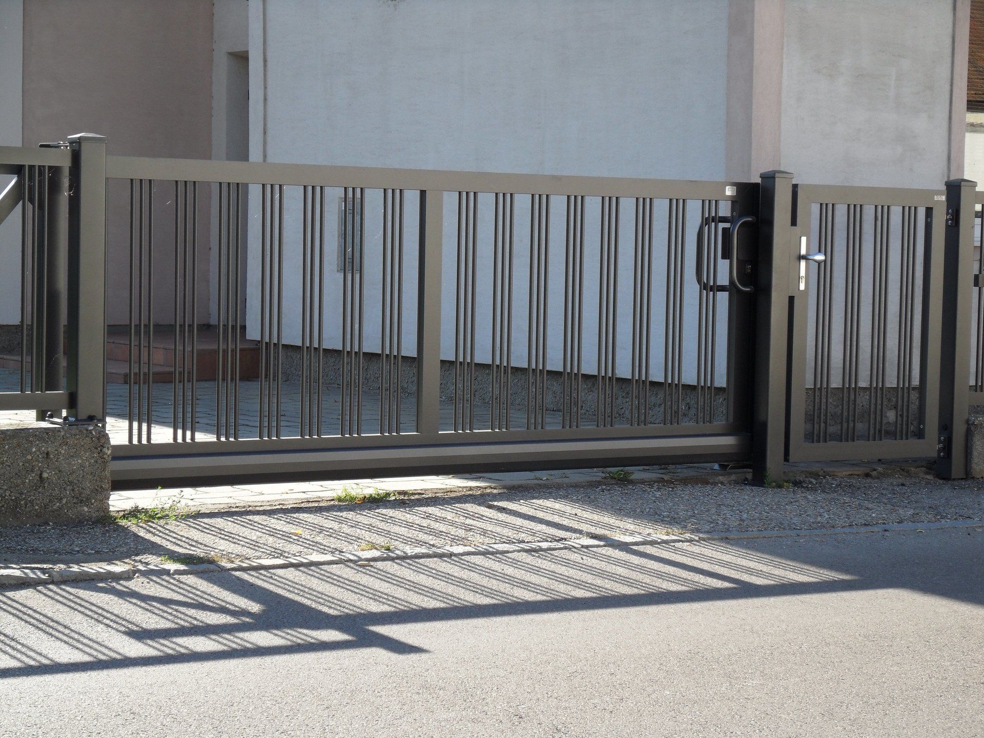 Ein Zaun mit Schiebetor vor einem Gebäude