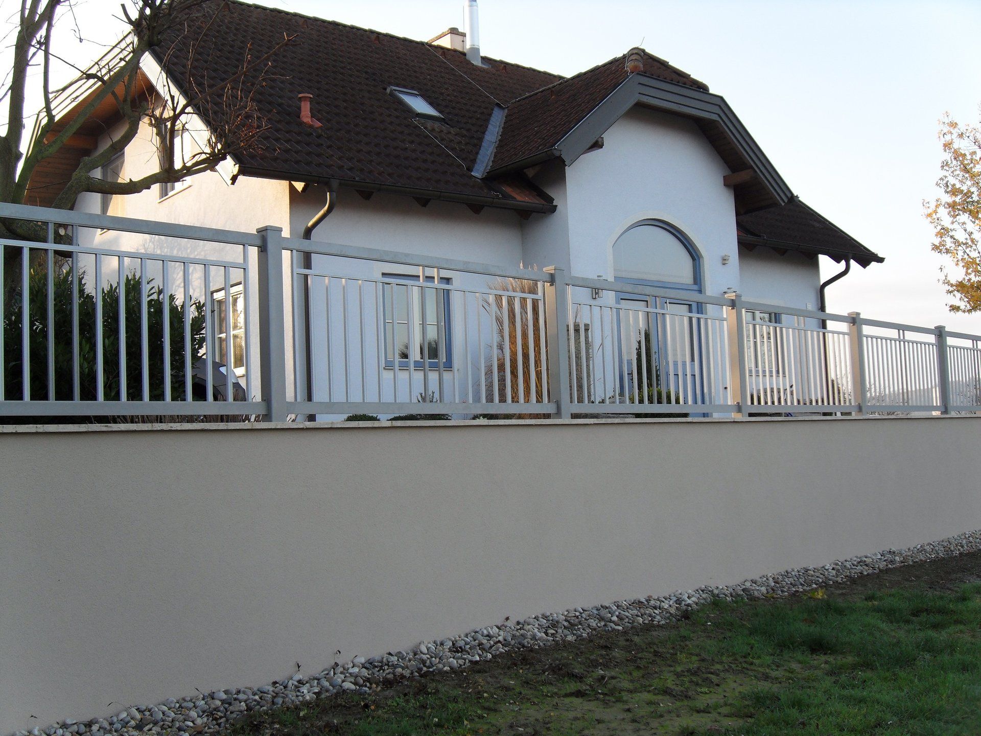 Ein weißes Haus mit einem Zaun davor