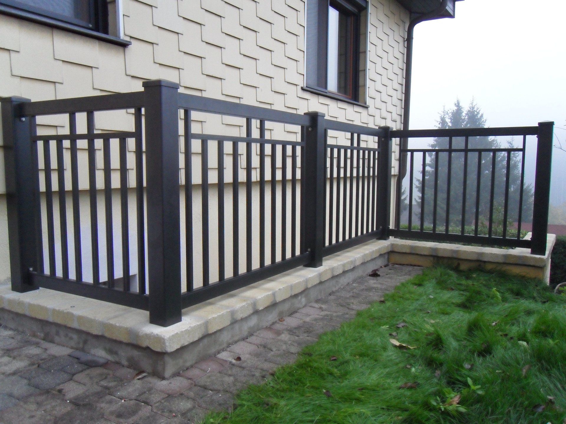 Ein Balkon mit einem schwarzen Geländer an der Seite eines Hauses