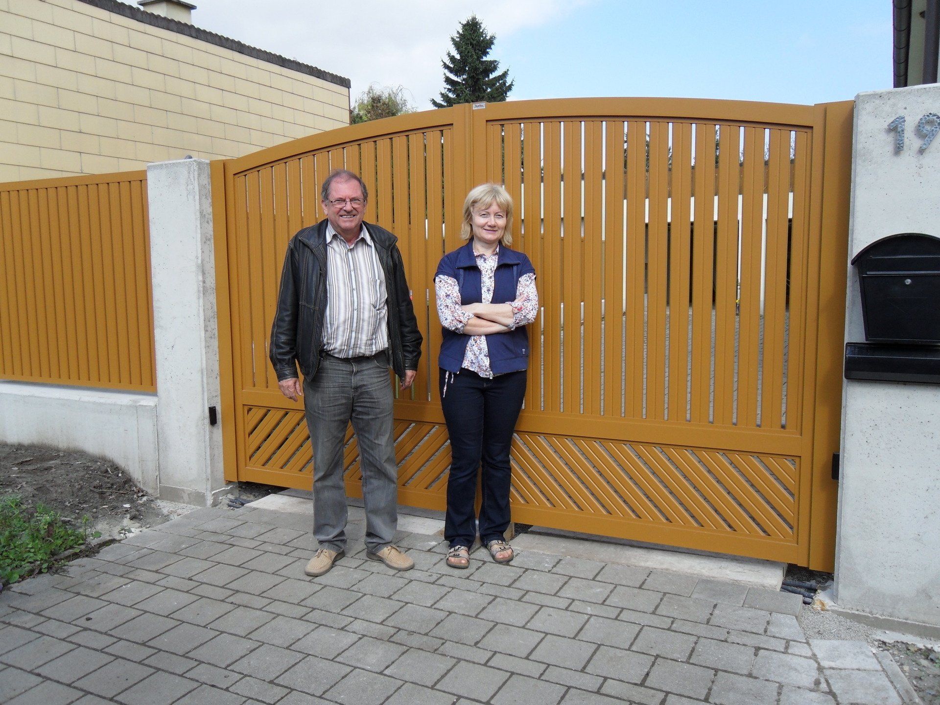 Ein Mann und eine Frau stehen vor einem Holztor