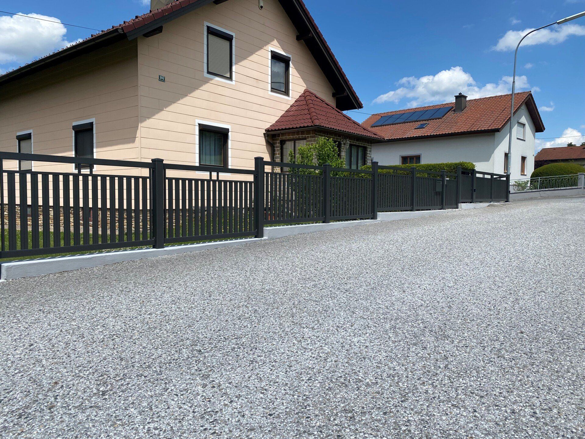 Ein Haus mit einem schwarzen Zaun darum herum