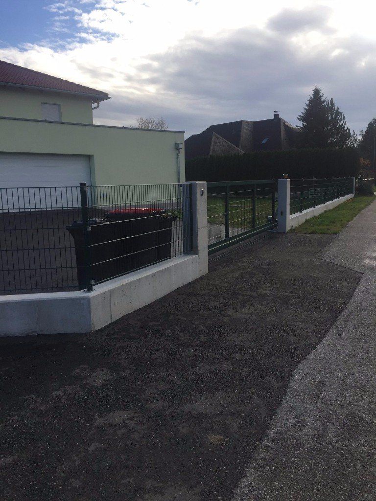 Ein Haus mit einem Zaun darum und einer Garage