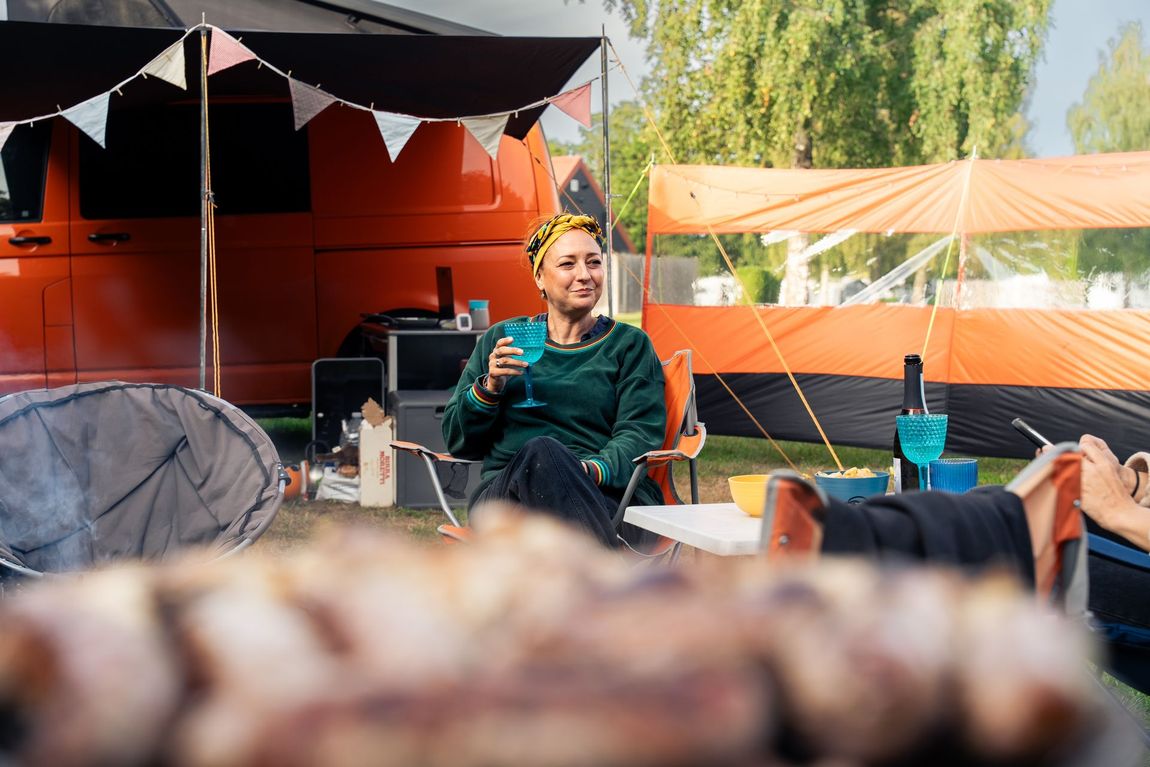 Coyote in snow, facing forward with a downward gaze, brown fur and light brown eyes.