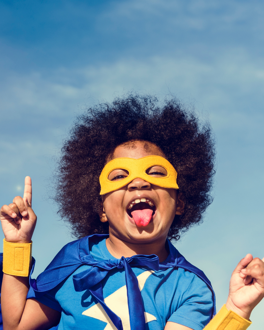 Easter Bunny character in a blue polka dot jacket standing in a daffodil patch