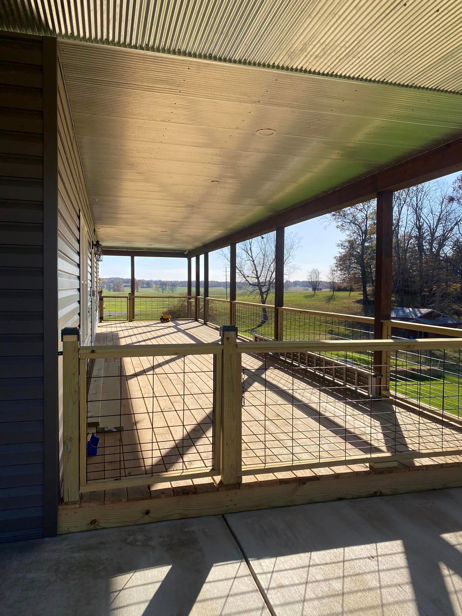 A Large Porch With A Fence And A View Of A Field - Princeton, IN - J. Koberstein Construction