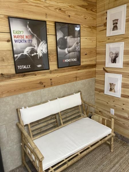 Wood-paneled waiting area with a bamboo bench and framed posters on the wall