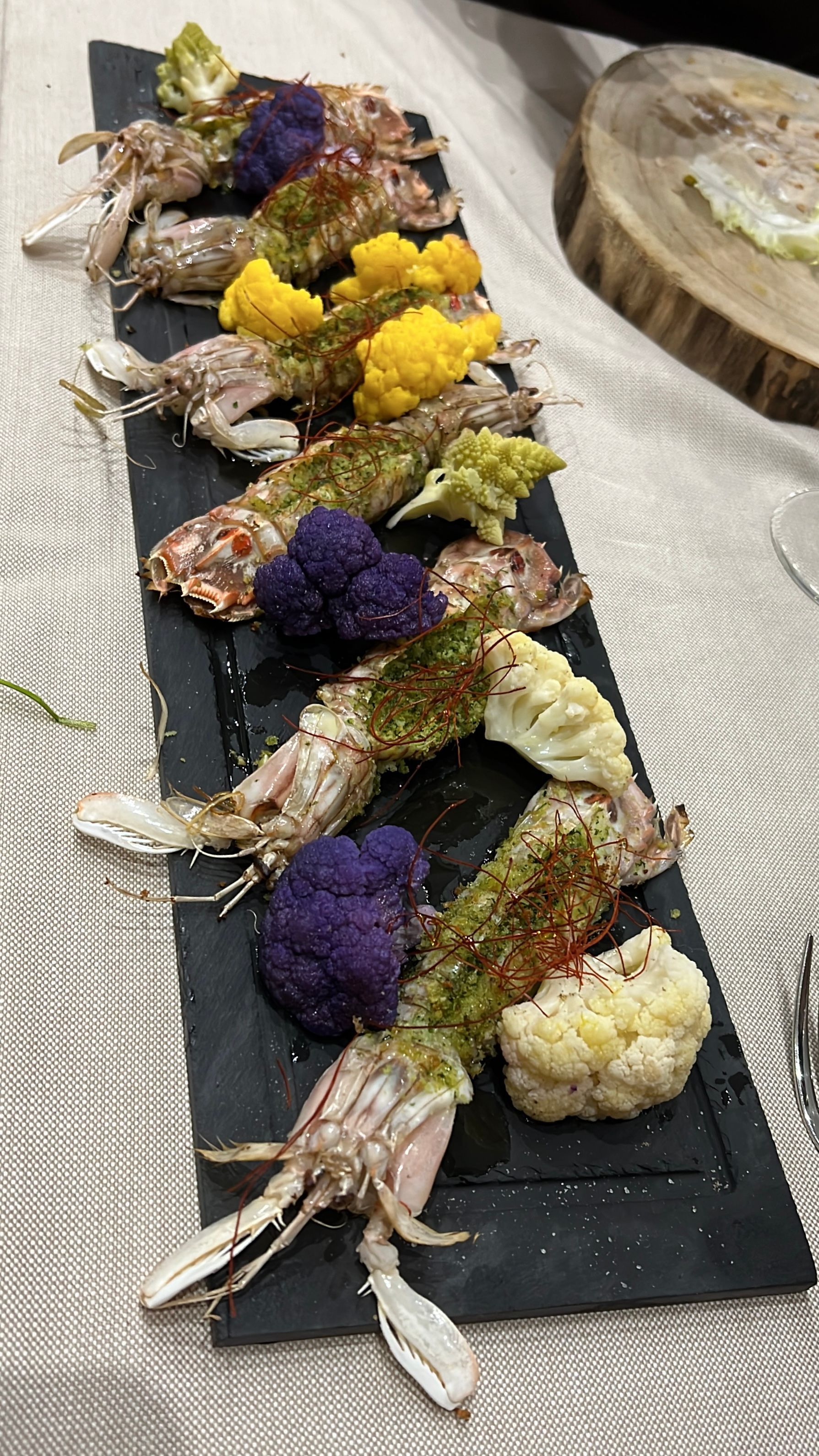 Una fila di cibo su un piatto nero su un tavolo.