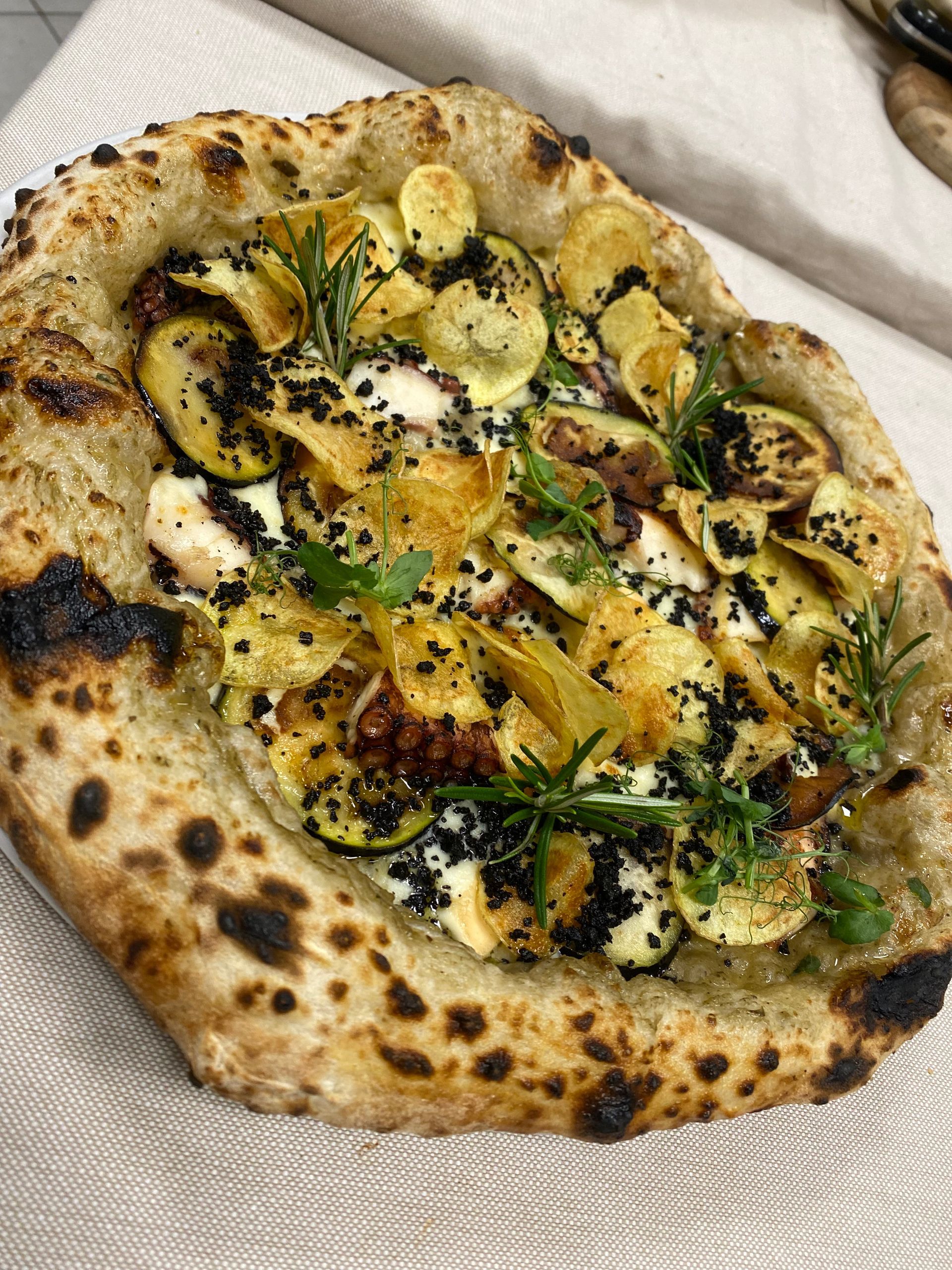 Una pizza con le verdure è appoggiata su un tavolo.