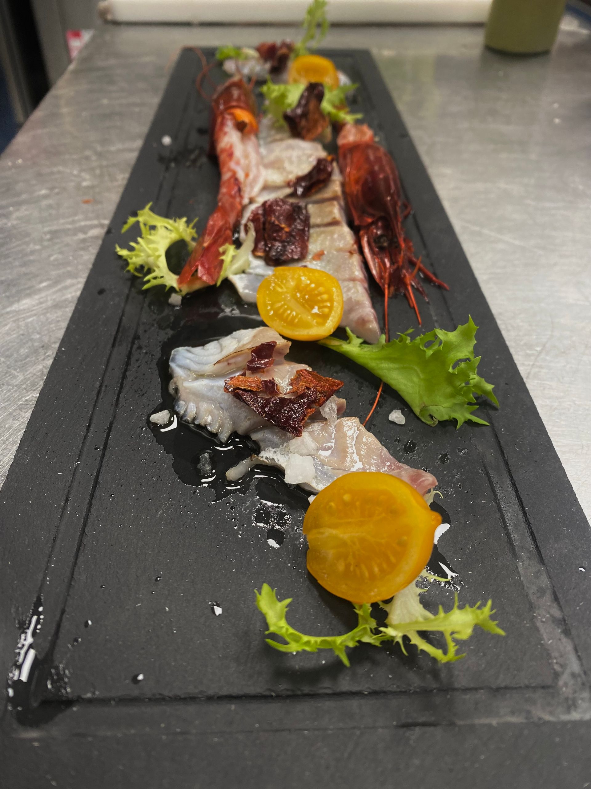 Un lungo piatto nero con un sacco di cibo sopra