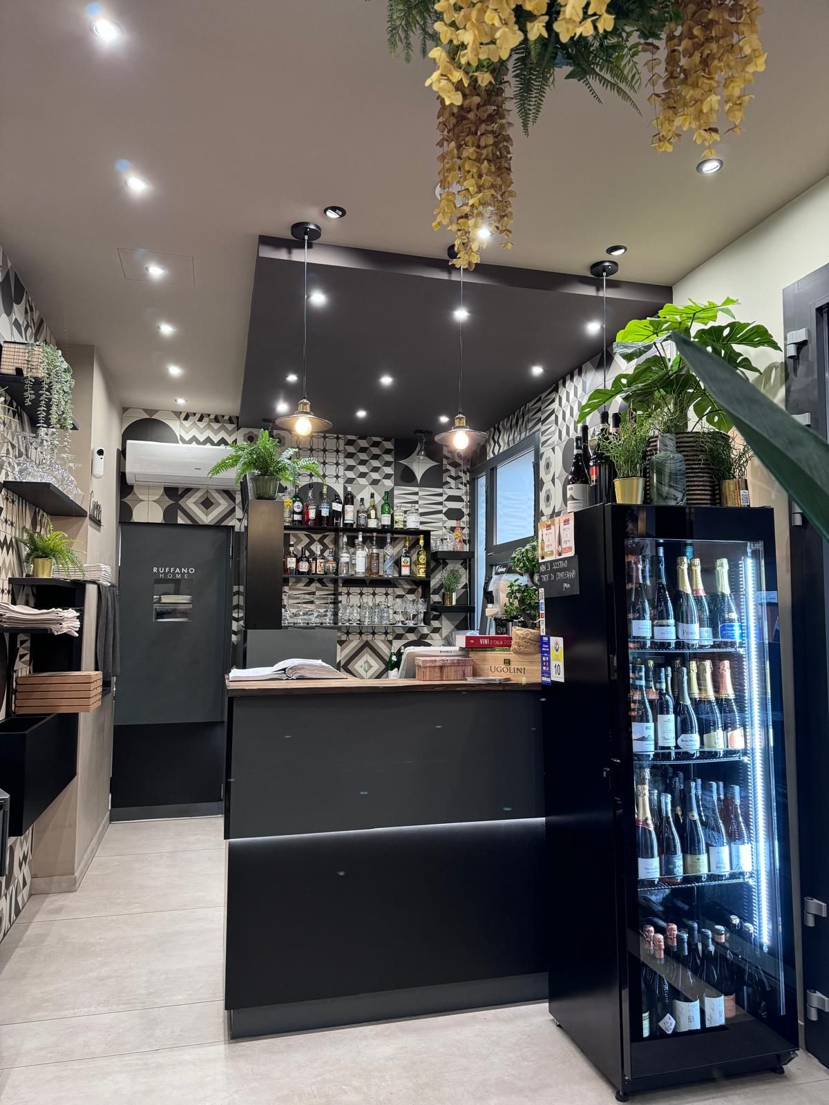 Un ristorante con un bancone e un frigorifero pieno di bottiglie di vino