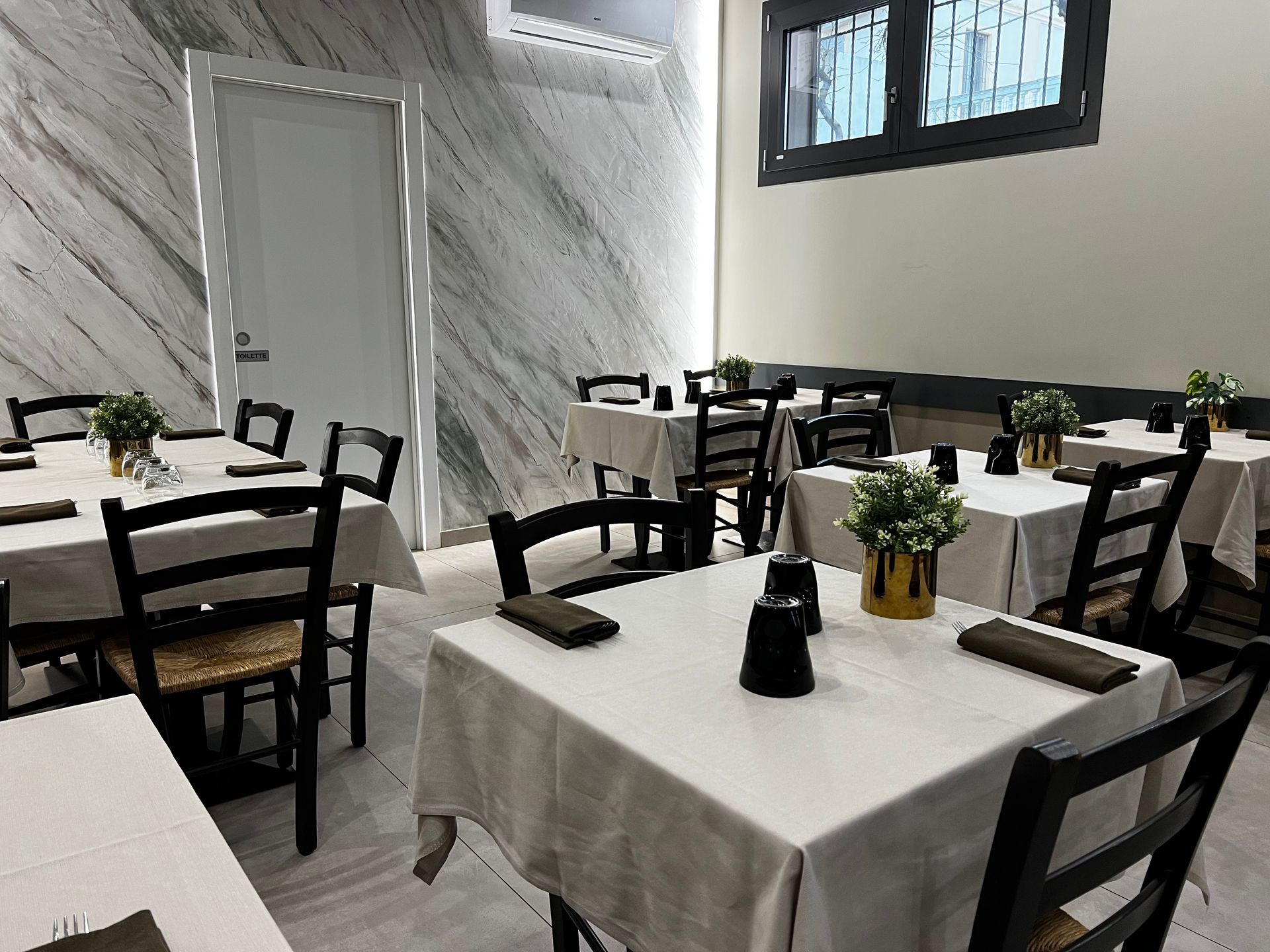 Un ristorante con tavoli e sedie allestiti per un pasto