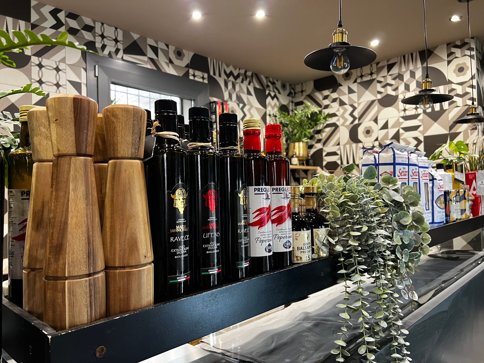 Uno scaffale pieno di bottiglie di vino e di saliere e pepiere.