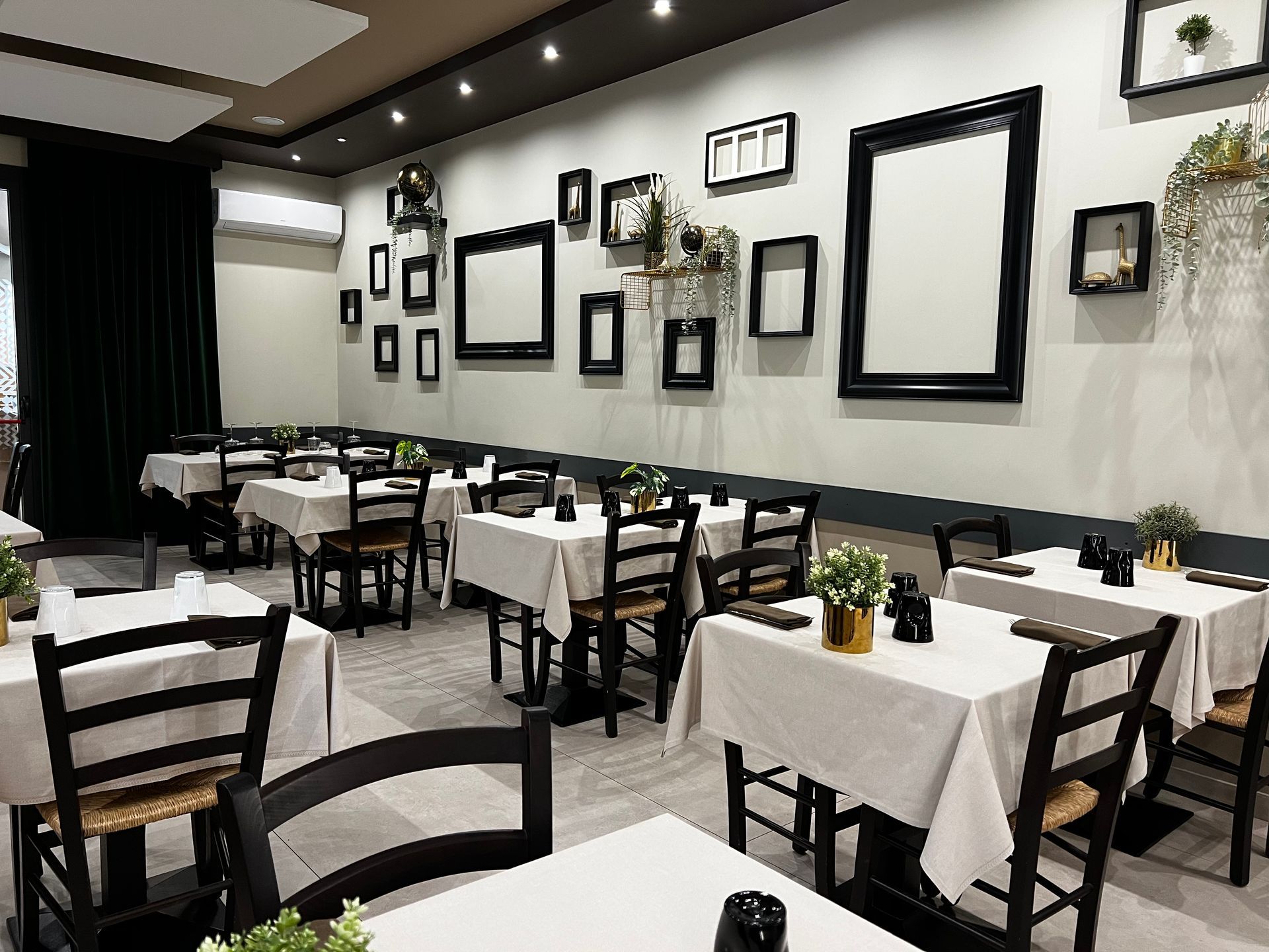 Un ristorante con tavoli e sedie e una parete con dei quadri.