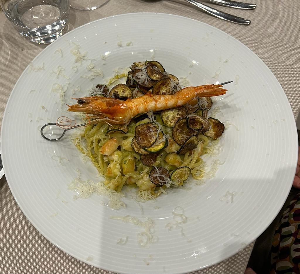 Un piatto di cibo con gamberi e tagliatelle su un tavolo.