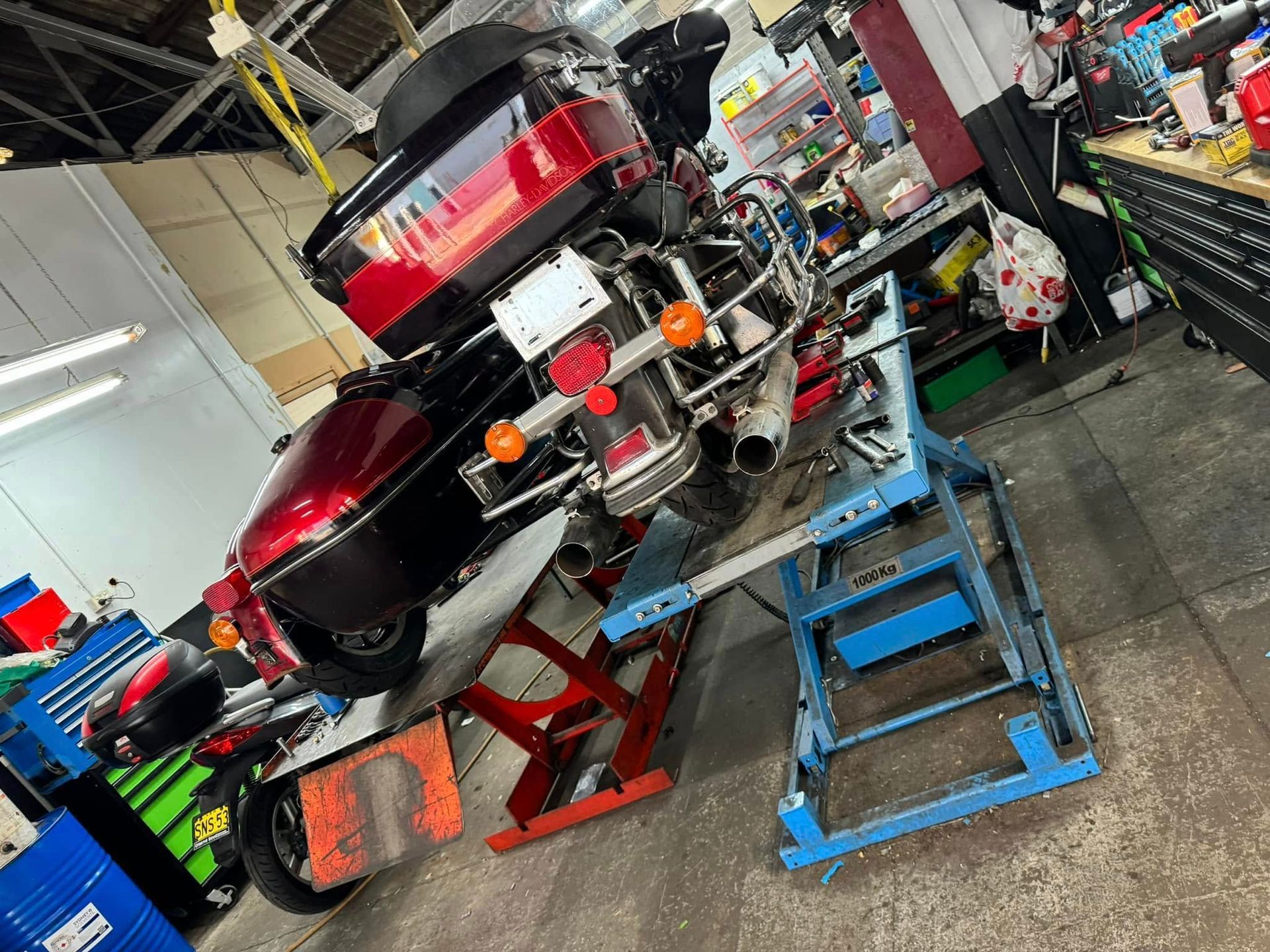 A Man is Working on a Motorcycle in a Garage — Newcastle Motorcycle Tyres in Broadmeadow, NSW