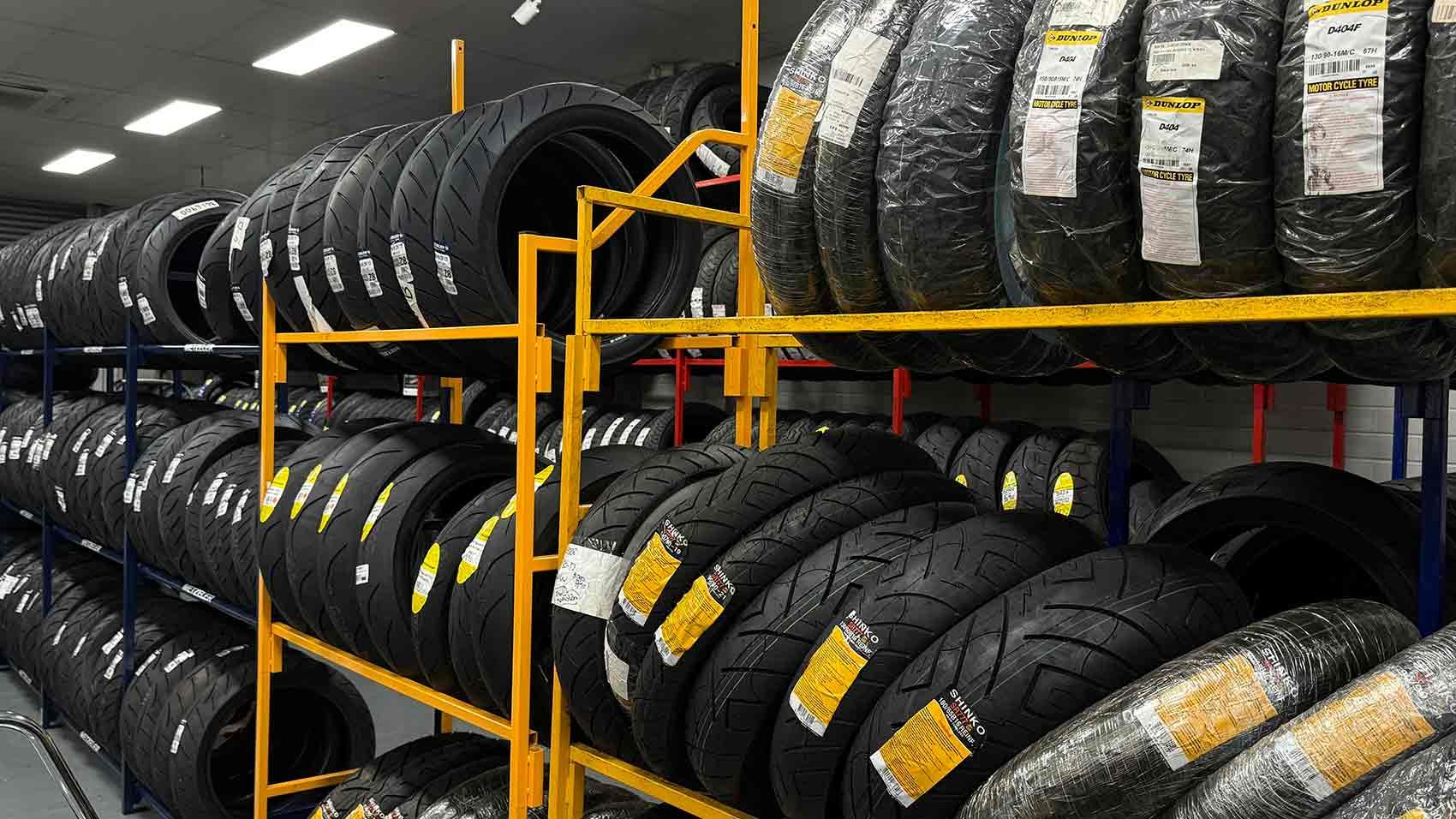 Rows of Motorcycle Tires on Yellow Metal Racks — Newcastle Motorcycle Tyres in Broadmeadow, NSW