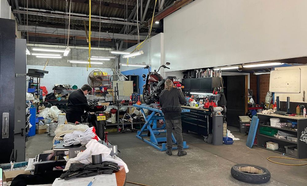 Men is Working on a Motorcycle in a Garage — Newcastle Motorcycle Tyres in Broadmeadow, NSW