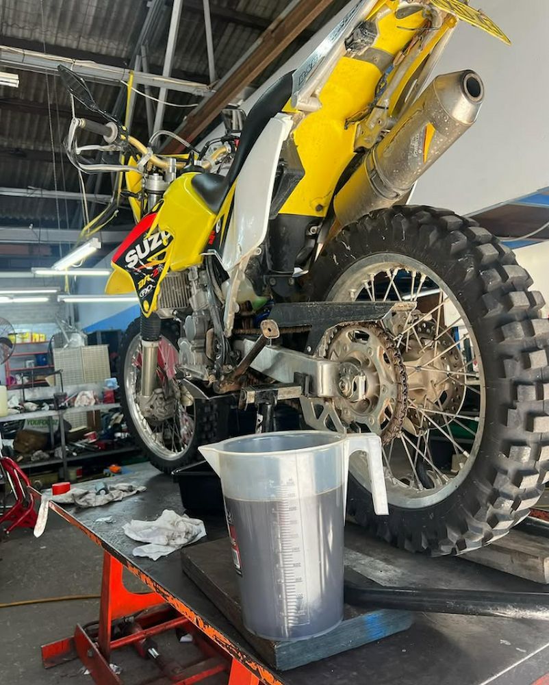 A Suzuki Dirt Bike is Being Worked on in a Garage — Newcastle Motorcycle Tyres in Broadmeadow, NSW