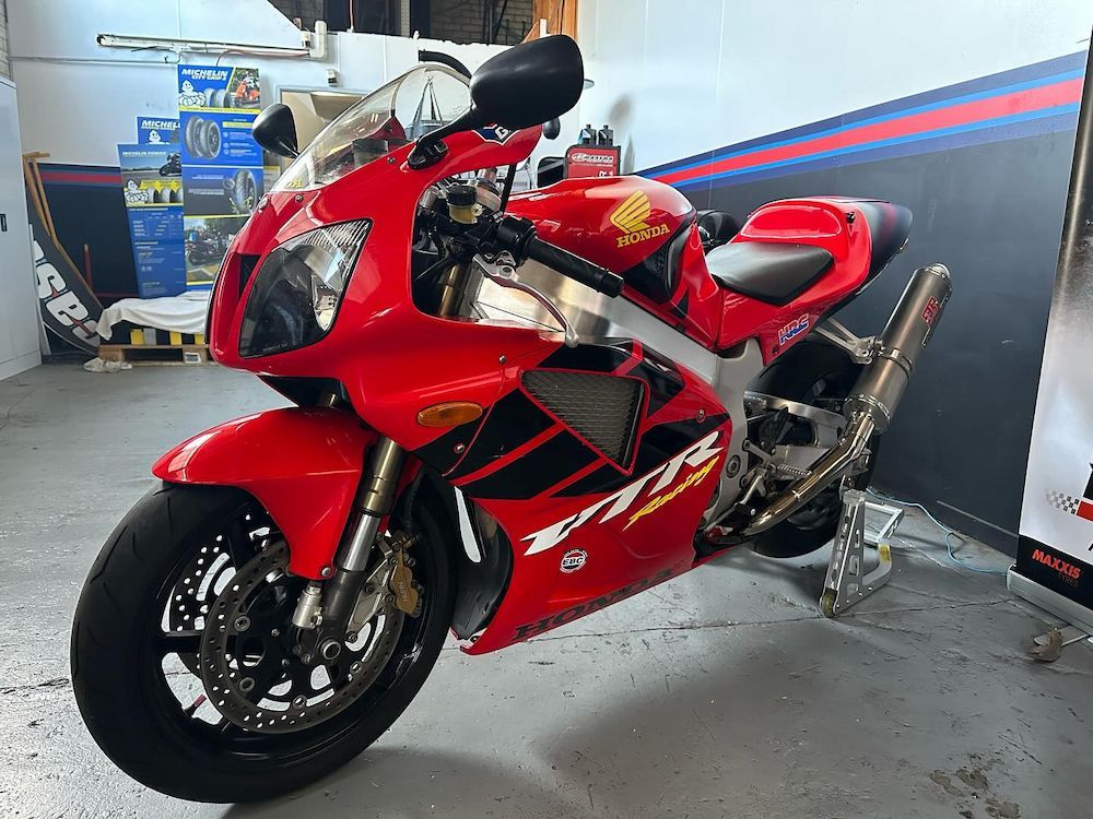 A Red Honda Motorcycle is Parked in a Garage — Newcastle Motorcycle Tyres in Broadmeadow, NSW