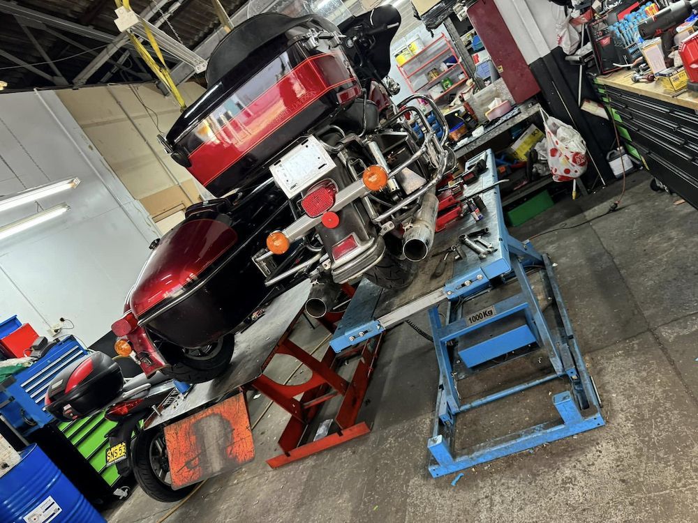 A Motorcycle is Sitting on a Lift in a Garage — Newcastle Motorcycle Tyres in Broadmeadow, NSW
