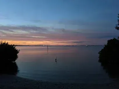 Hvac-Contractor-Bradenton-A sunset over a body of water with trees in the foreground.