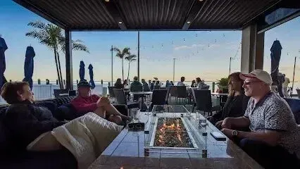 Hvac-Contractor-Bradenton-A group of people are sitting around a table with a fire pit.
