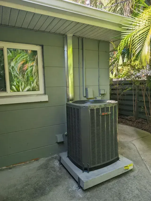 Hvac Contractor Bradenton - A large air conditioner is sitting outside of a house next to a window.