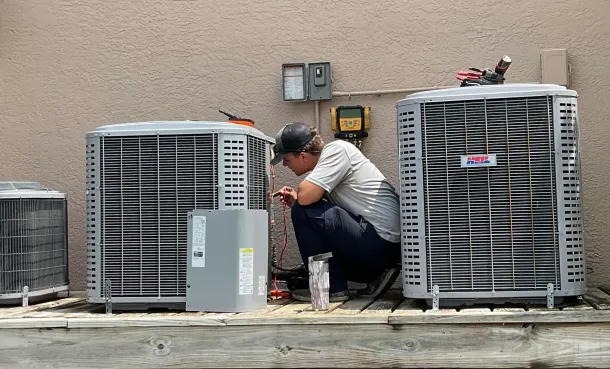 Hvac Contractor Bradenton - a man is working on an air conditioner on the roof of a building .