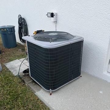 a large air conditioner is sitting on the side of a house .