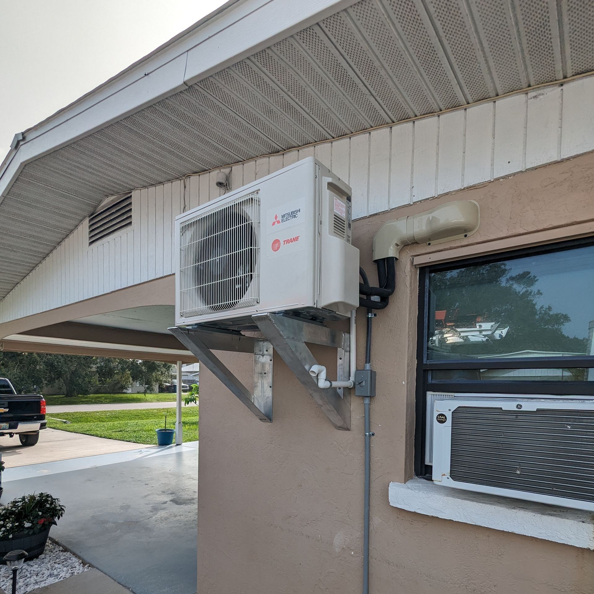 a mitsubishi air conditioner is mounted on the side of a house