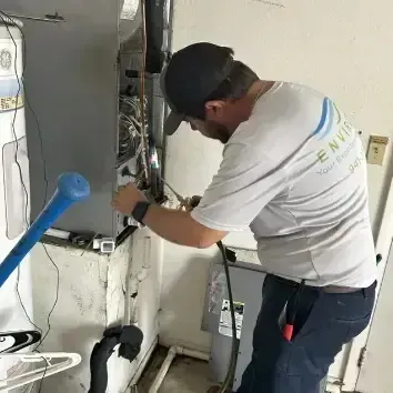 Hvac-Contractor-Bradenton-A man is working on an air conditioner in a garage.