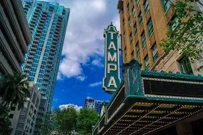 Hvac-Contractor-Bradenton-Tampa Theatre sign, Art Deco style, with high-rise buildings in the background on a sunny day.