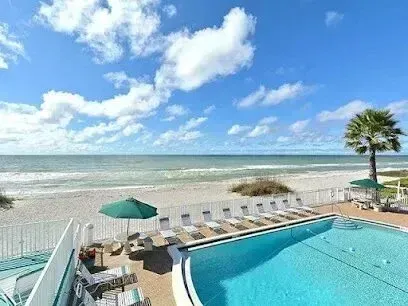 Hvac-Contractor-Bradenton-A large swimming pool surrounded by chairs and umbrellas next to a beach.