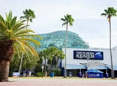 Hvac-Contractor-Bradenton-The Florida Aquarium with a glass domed roof, blue and white exterior, and palm trees in Tampa.