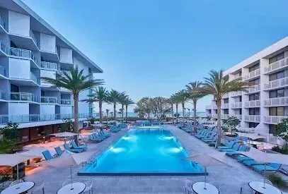 Hvac-Contractor-Bradenton-A large swimming pool surrounded by chairs and tables in front of a hotel.