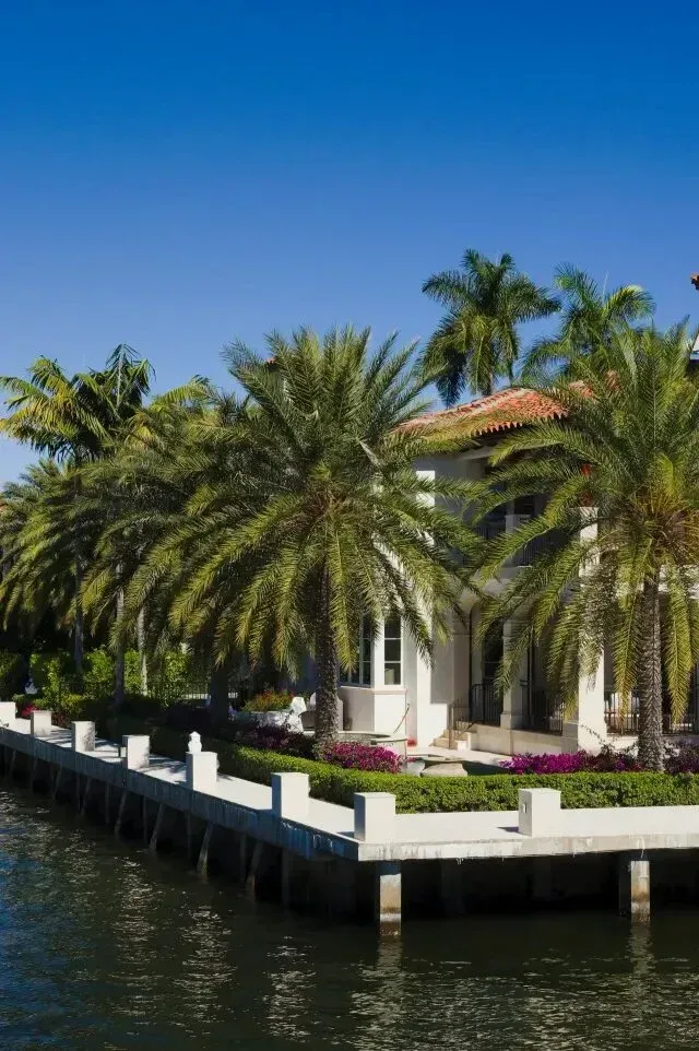 hvac-contractor-Waterfront home with palm trees and blue sky.