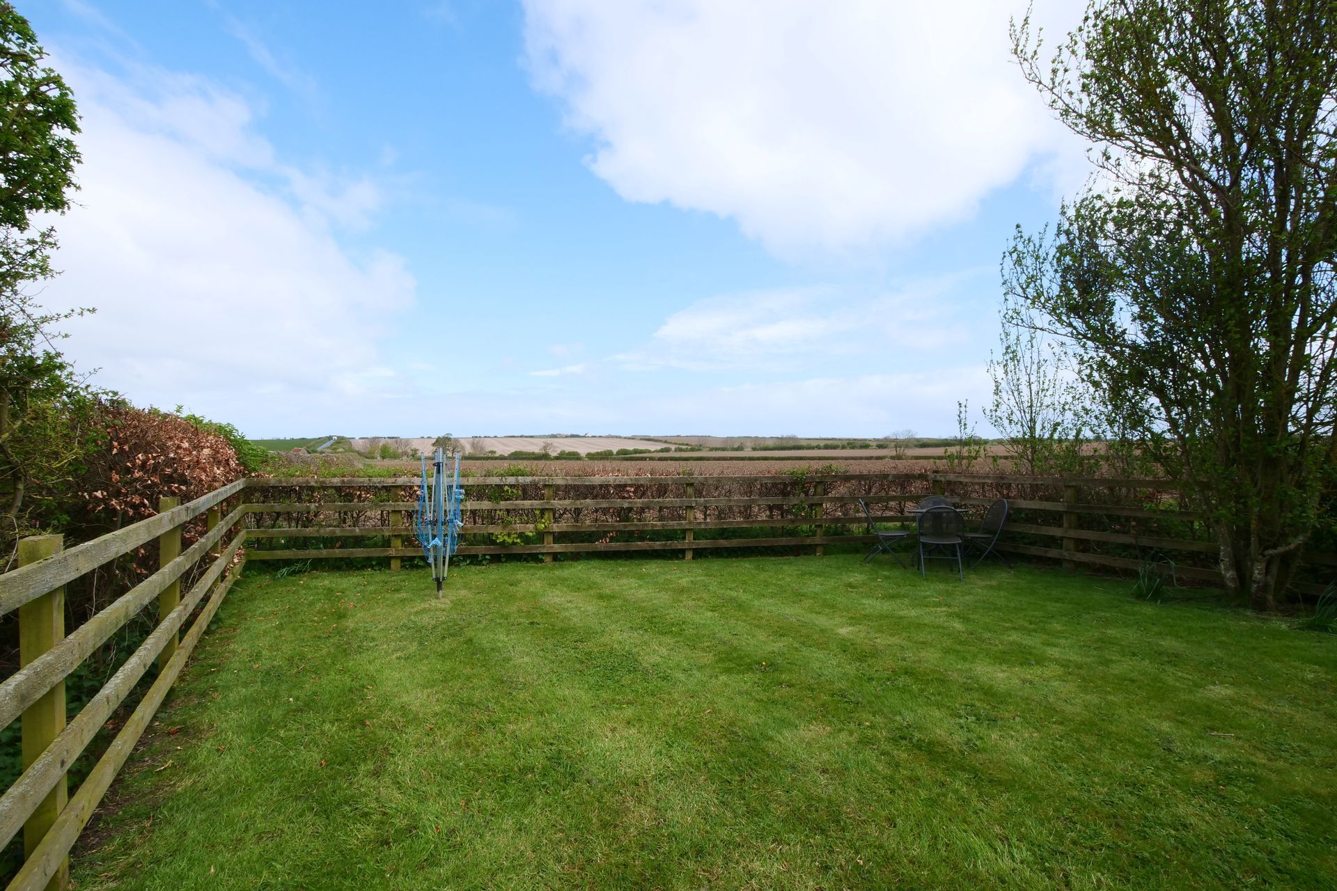 A large lawn with a wooden fence surrounding it