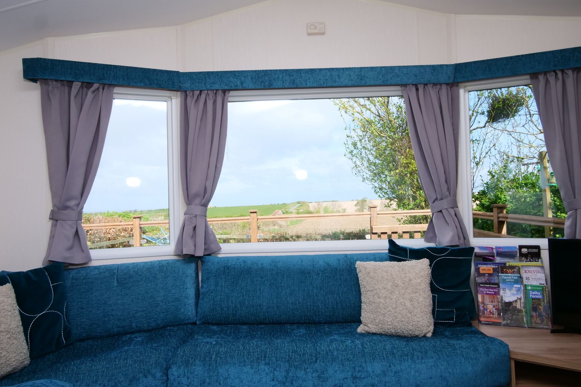 A living room with a blue couch and a large window.