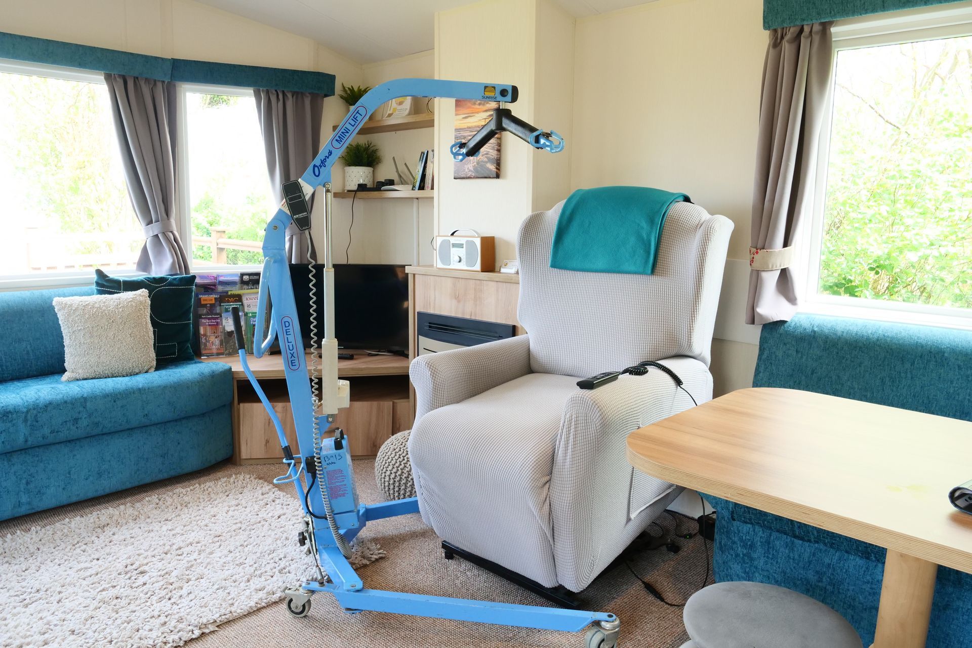 A chair lift is in a living room next to a couch.