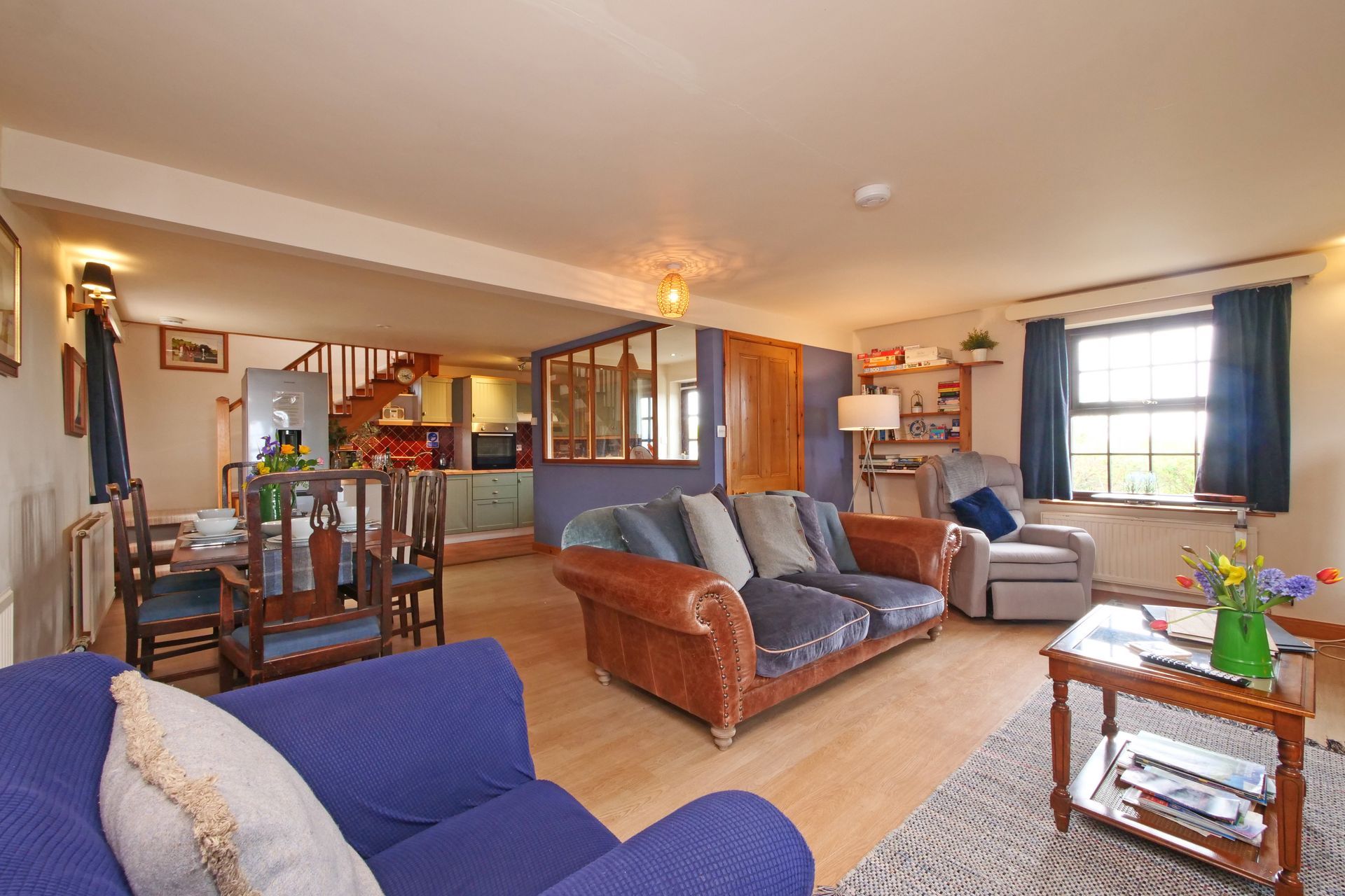 A living room with a blue couch and a brown couch