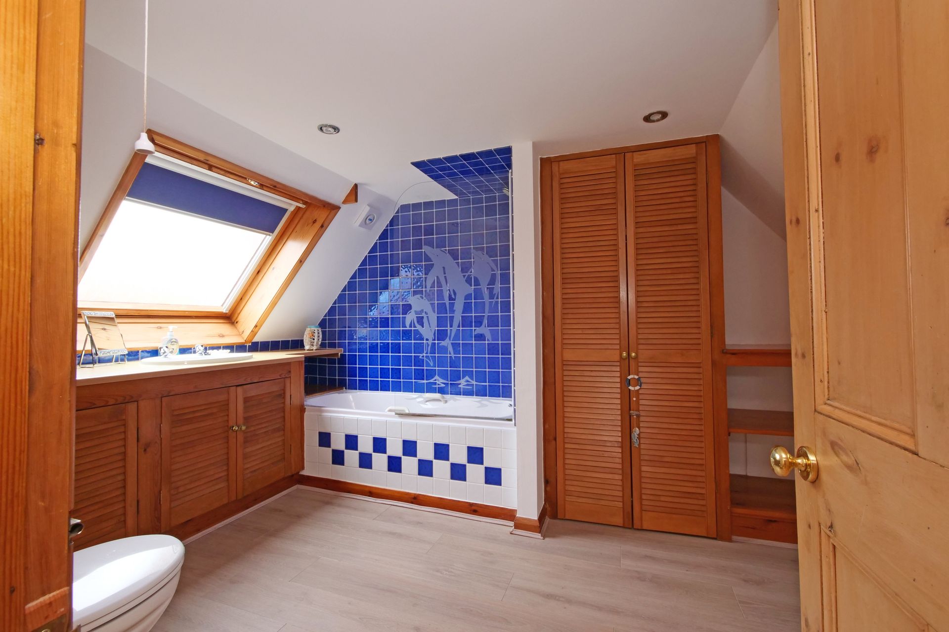 A bathroom with blue and white tiles and a skylight